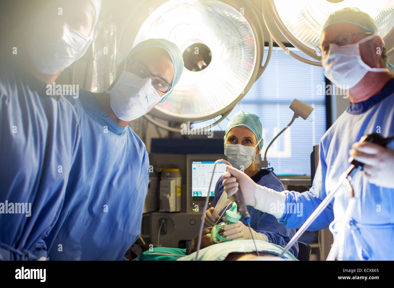 Team di medici di eseguire la chirurgia laparoscopica in sala operatoria Foto Stock