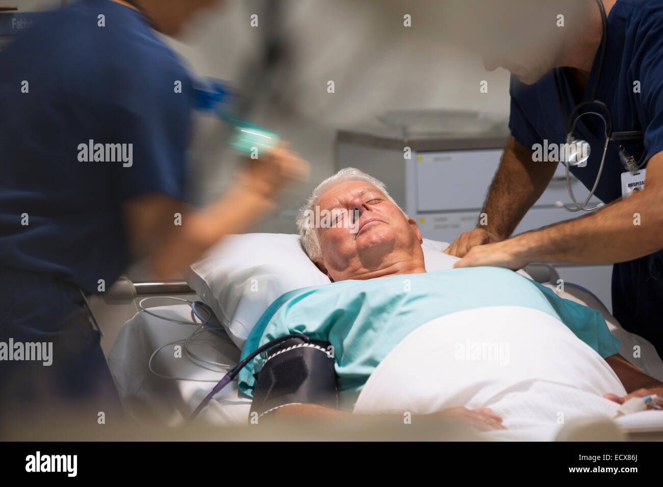 Senior paziente che riceve il trattamento medico in unità di terapia intensiva Foto Stock