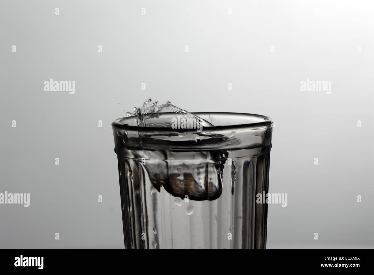 Gli spruzzi e le gocce di acqua in vetro sfaccettate Foto Stock