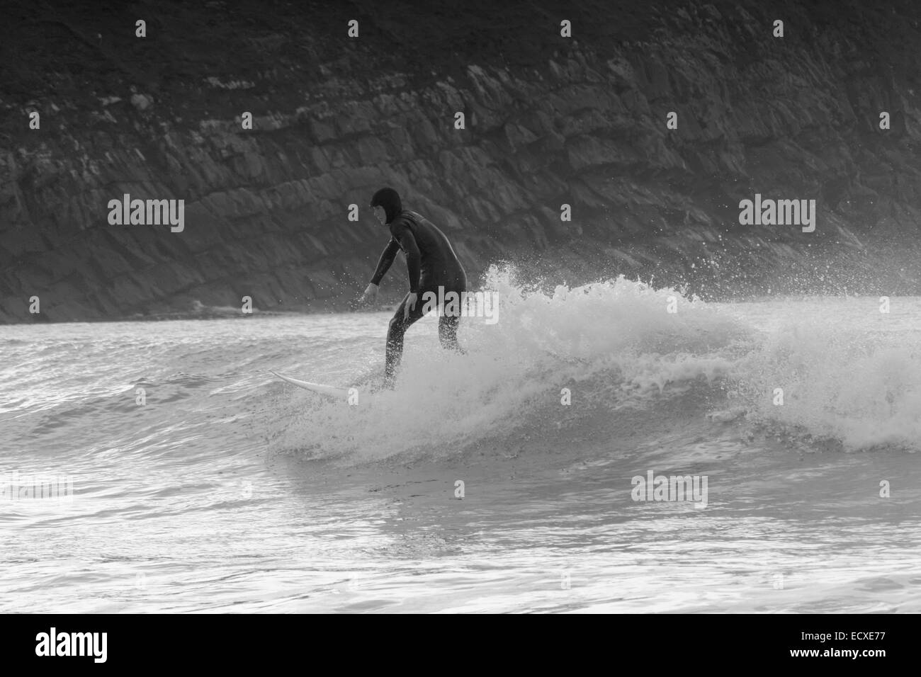 Buone condizioni di mare consente un surfista a guidare una buona forma d'onda per un lungo periodo a Porth Neigwl, il Galles del Nord Foto Stock