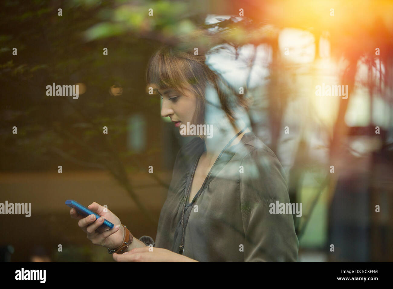 Imprenditrice utilizzando il cellulare in ufficio Foto Stock