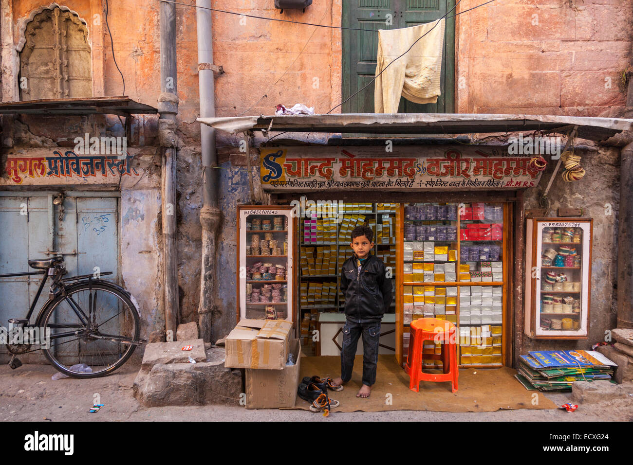 Ragazzo indiano in piedi al di fuori della sua famiglia shop a Jodhpur, Rajasthan, India Foto Stock