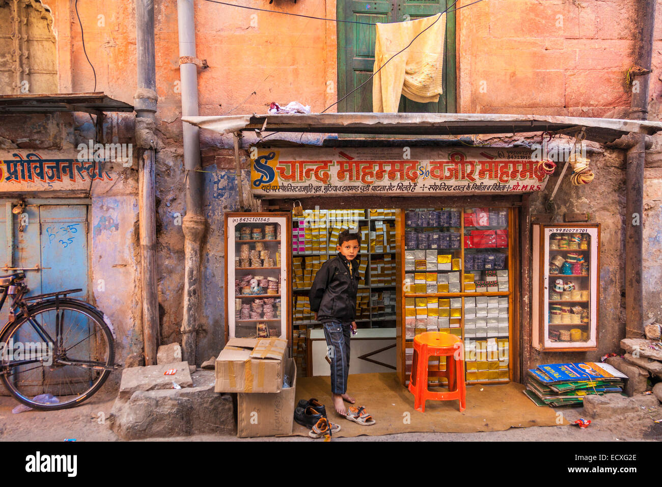 Ragazzo indiano in piedi al di fuori di un negozio di Jodhpur, Rajasthan, India Foto Stock