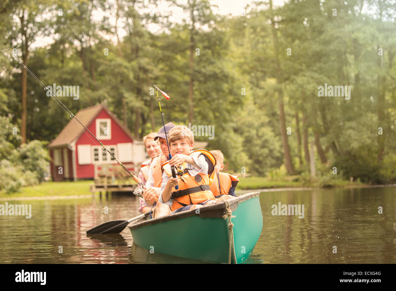 Padre e figli da pesca canoa nel lago Foto Stock
