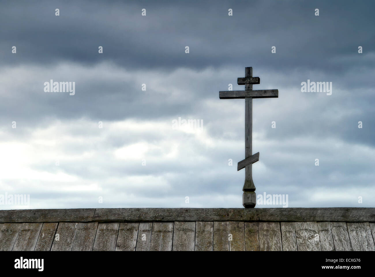 Croce ortodossa sulla parte superiore del tetto contro il cielo di pioggia. Foto Stock