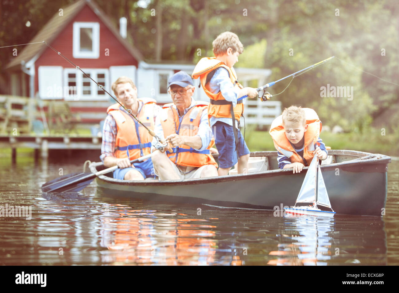 Fratelli, padre e mio nonno pesca in canoa sul lago Foto Stock