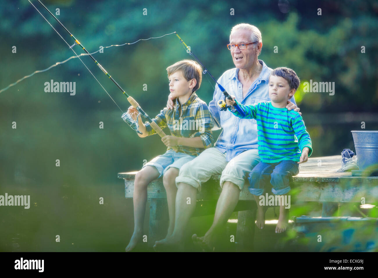 Nonno e nipoti la pesca nel lago Foto Stock