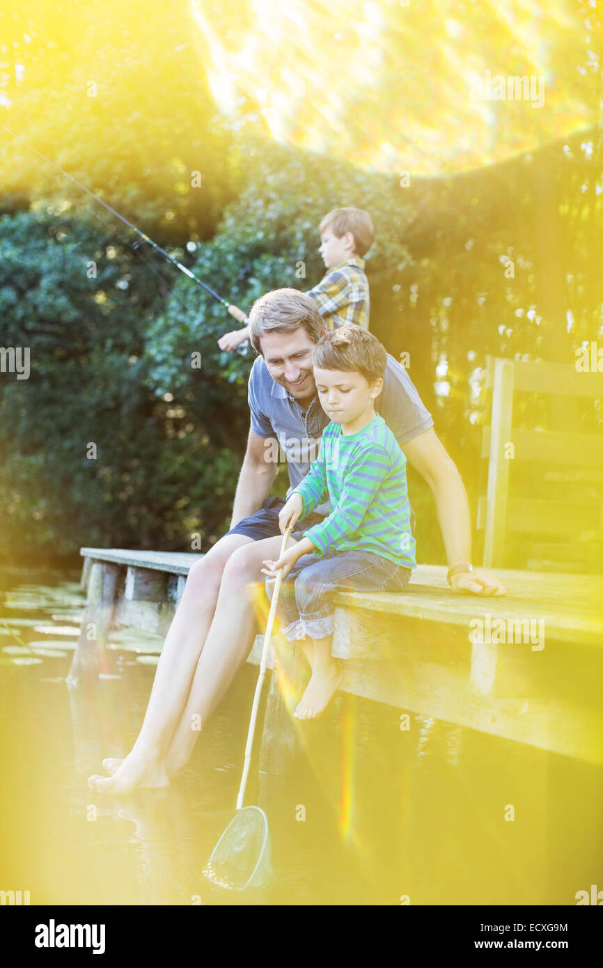 Padre e figli pesca dal dock Foto Stock