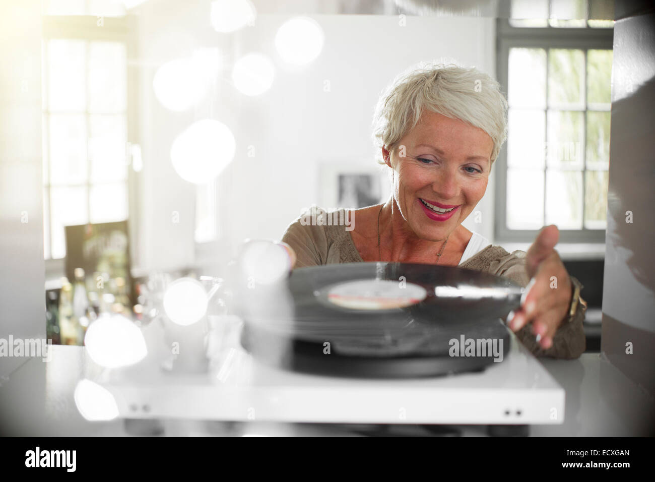 Donna anziana la riproduzione di dischi in vinile sul giradischi Foto Stock