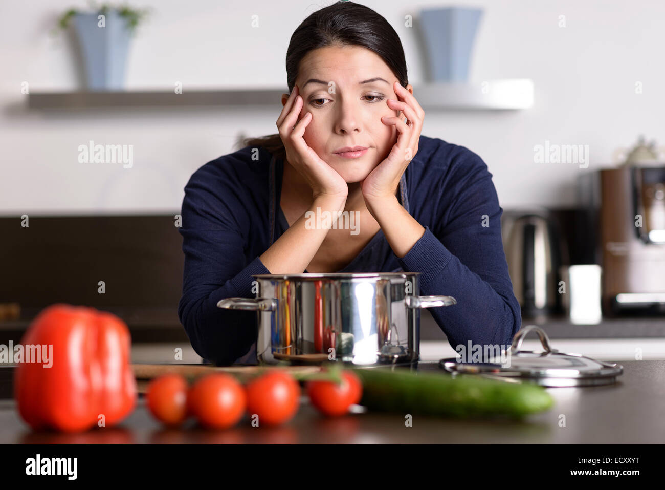 Demotivato attraente giovane donna preparare la cena appoggiata sul piano di cottura occhiatura la verdura fresca con una fiacca glum expr Foto Stock