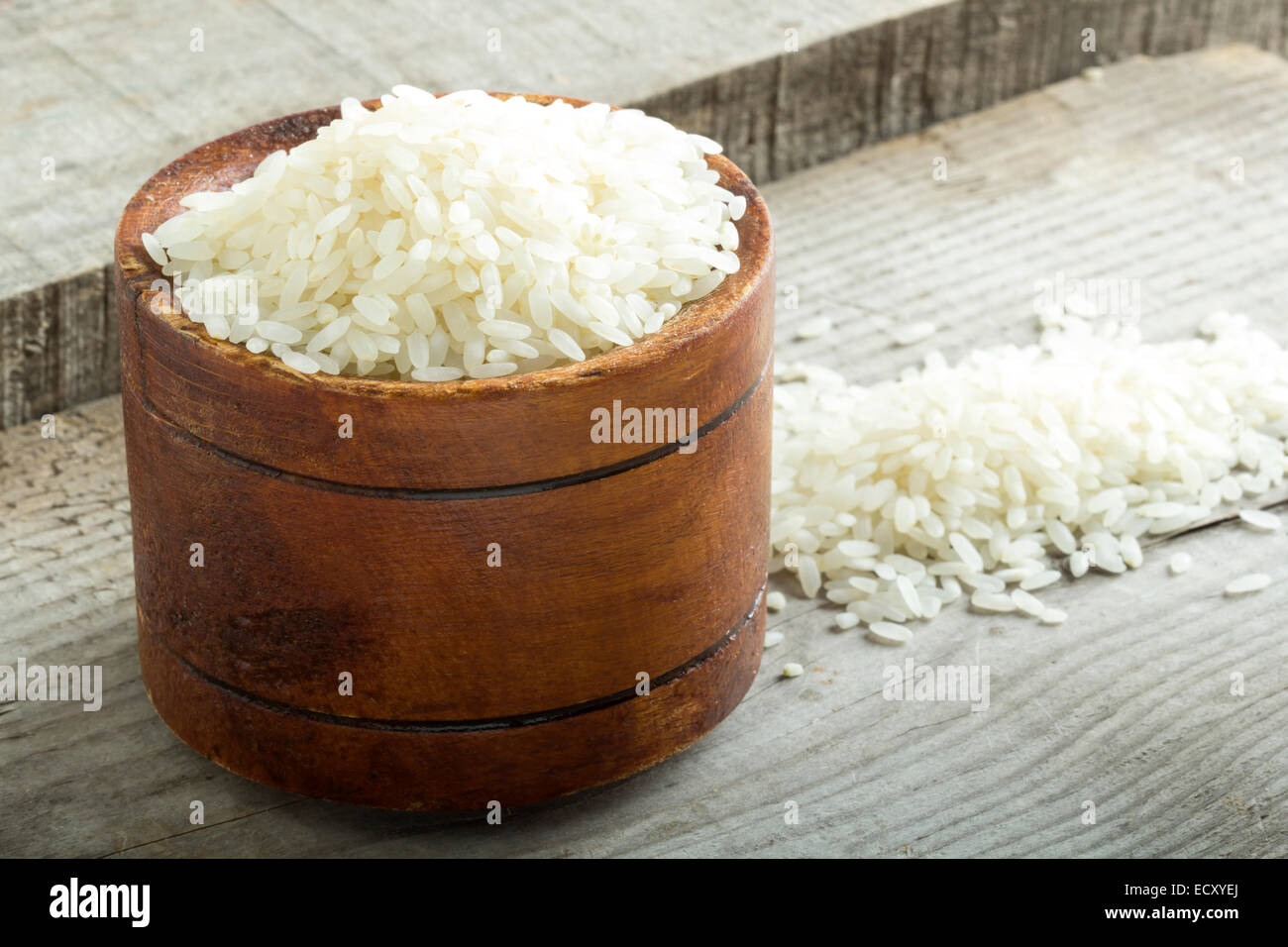 Il riso nella ciotola di legno scuro dello sfondo Foto Stock