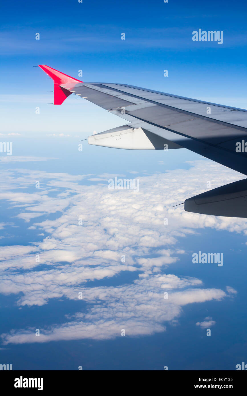 Aereo ad ala volare al di sopra delle nuvole guardando il cielo dalla finestra, utilizzando il trasporto aereo per viaggi. Foto Stock