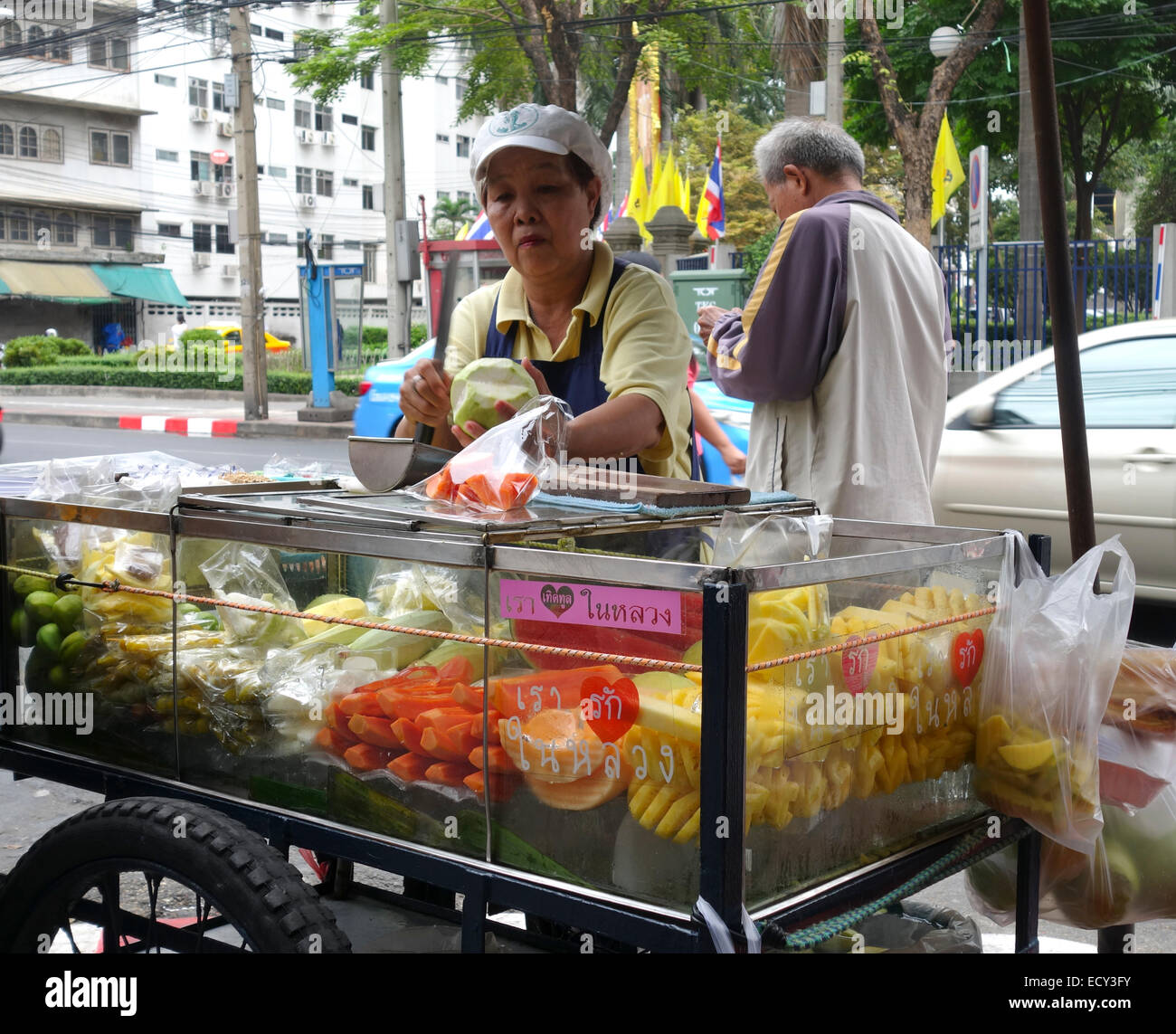 Frutta cibo di strada, venditore, donna, il fornitore in posizione di stallo in Bangkok. Thailandia, Sud-est asiatico. Foto Stock