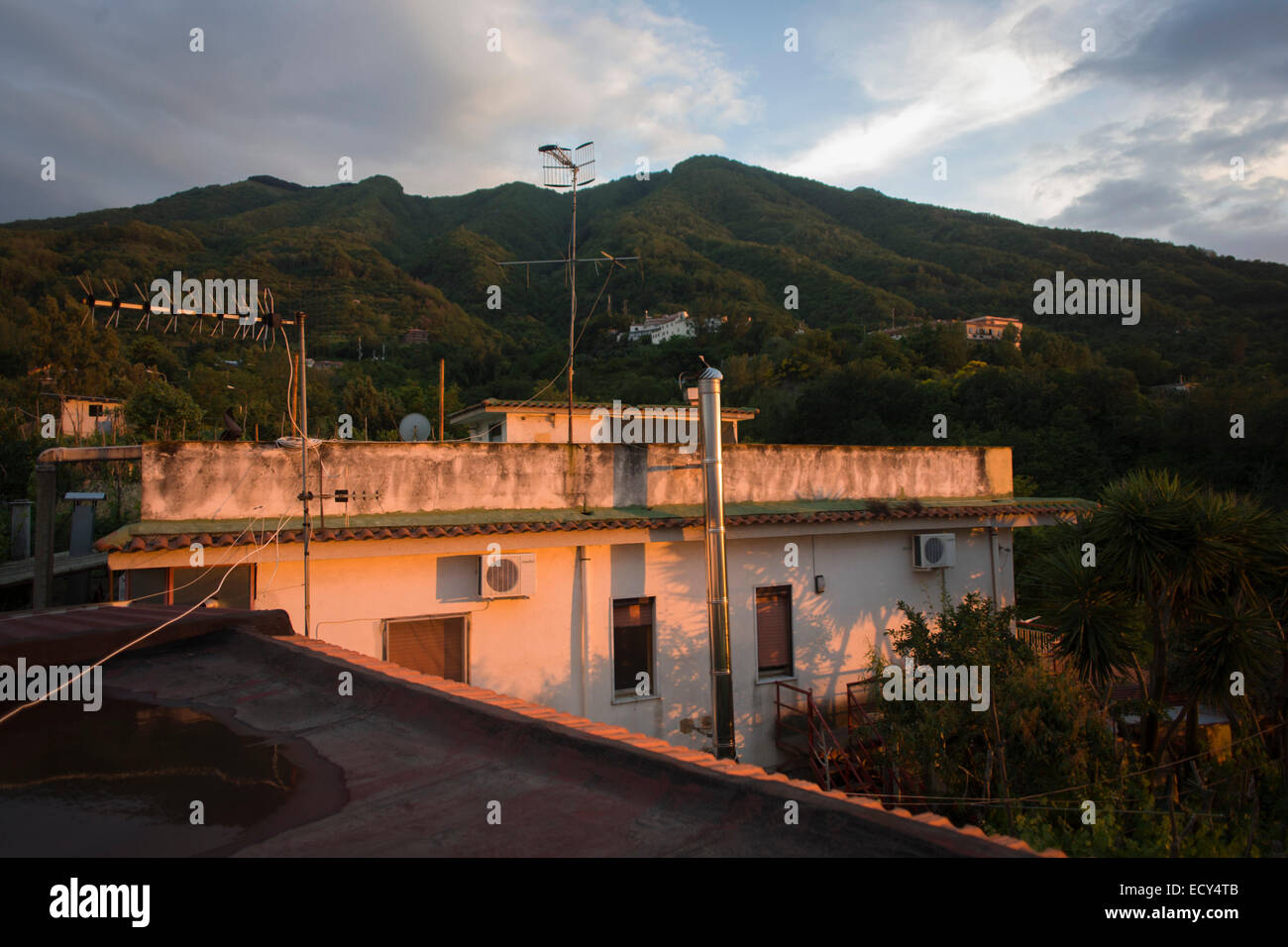 Case arroccato sulle pendici del Vesuvio, visto in lontananza la cui ultima eruzione risale al 1944. Foto Stock