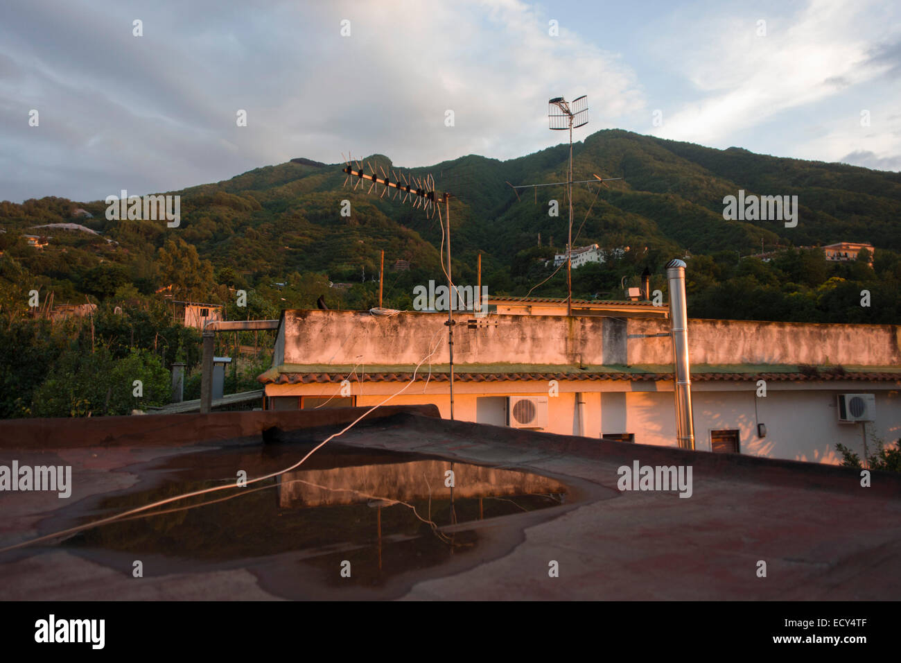 Case arroccato sulle pendici del Vesuvio, visto in lontananza la cui ultima eruzione risale al 1944. Foto Stock