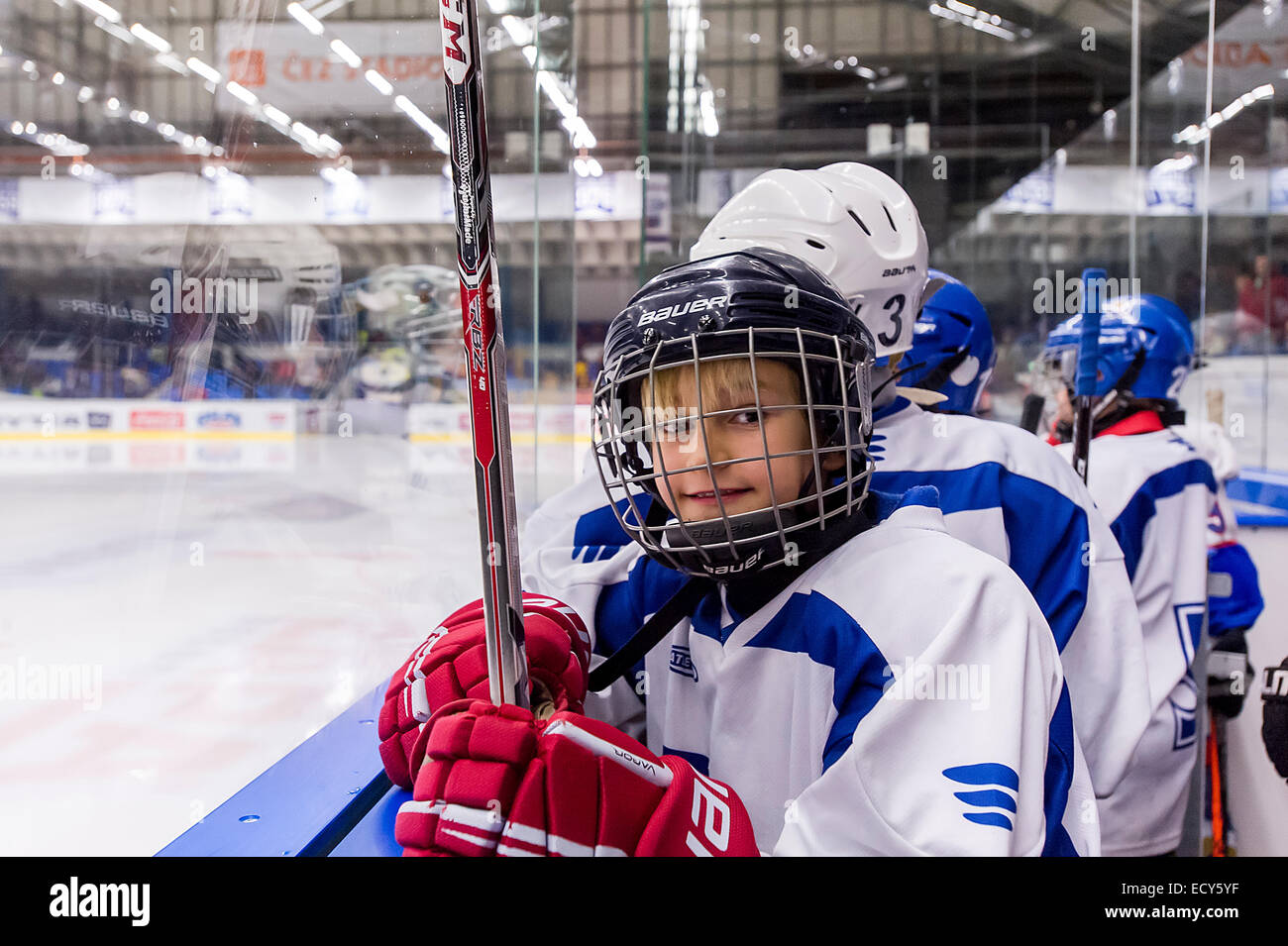 Giovani ice-giocatore di hockey in piedi dietro al pannello Foto Stock