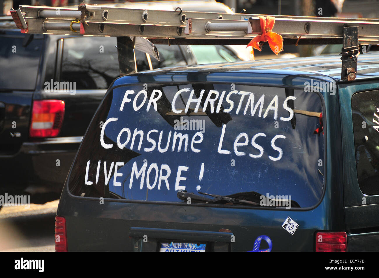 Invito a ridurre i consumi, la scrittura su una finestra posteriore " per Natale, consumano meno, live più', New York New York Foto Stock