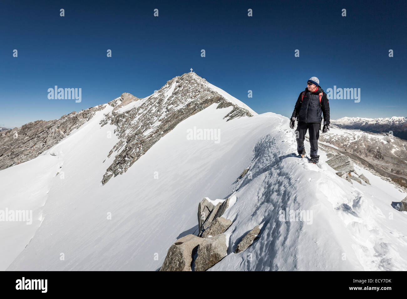 Alpinista durante la salita alla Hohe Weißzint, qui al vertice ridge, dietro il vertice con la croce, sul confine Foto Stock