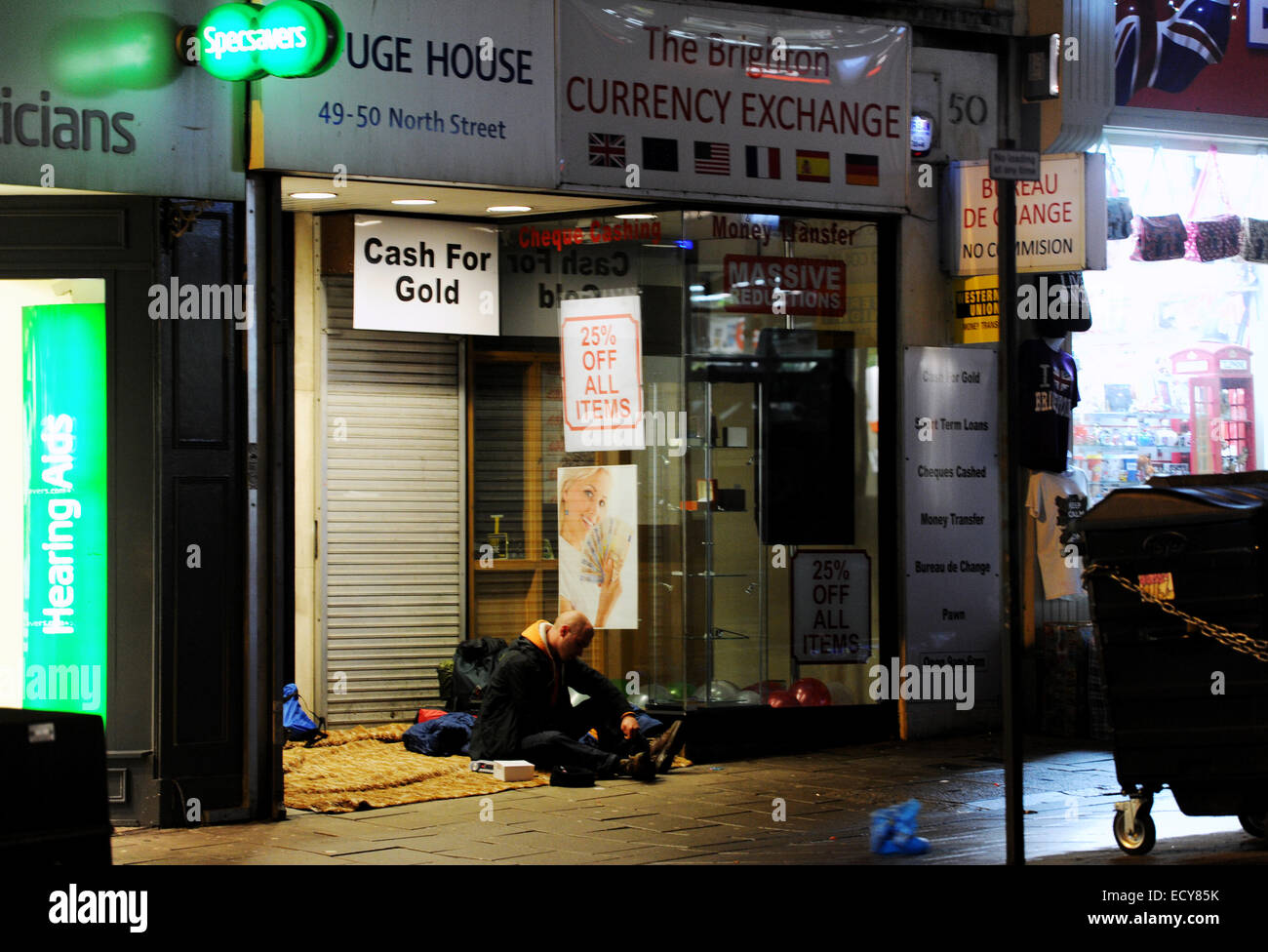 Brighton Regno Unito 21 Dicembre 2014 - uomo senza tetto la preparazione di dormire in modo irregolare a una porta nel North Street Brighton per la notte di Natale Foto Stock