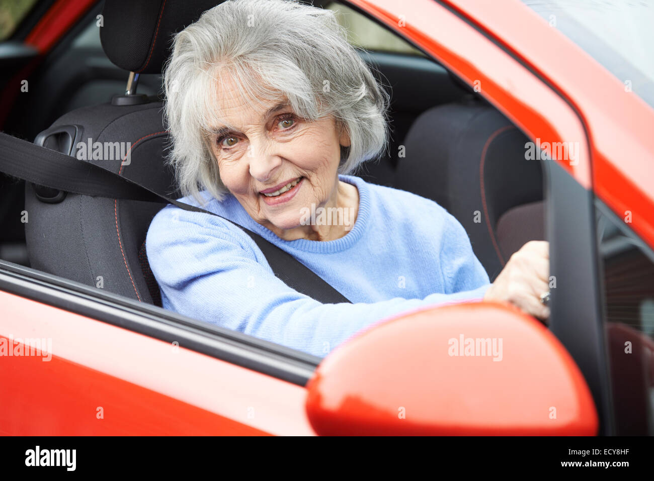 Ritratto di sorridere Senior donna alla guida di auto Foto Stock