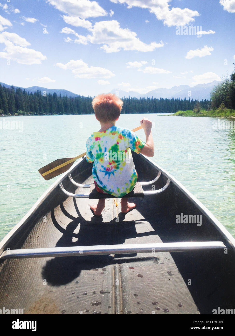 Ragazzo caucasico canottaggio canoa sul lago ancora Foto Stock