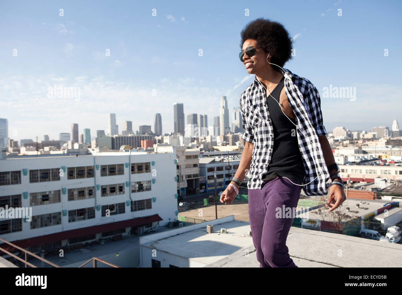 African American uomo in piedi sul tetto urbano Foto Stock