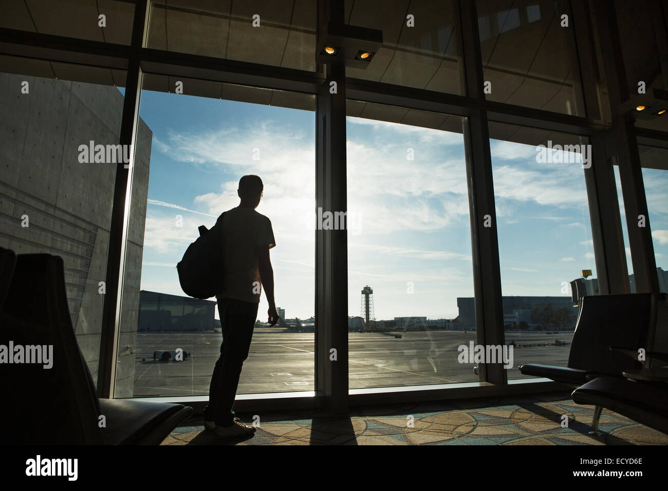 Silhouette di uomo a guardare fuori dalla finestra di airport Foto Stock