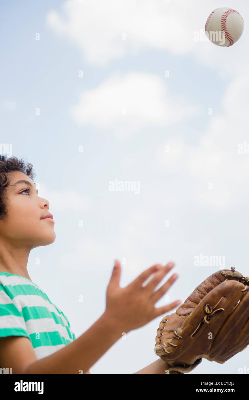 Razza mista boy gettando baseball all'aperto Foto Stock