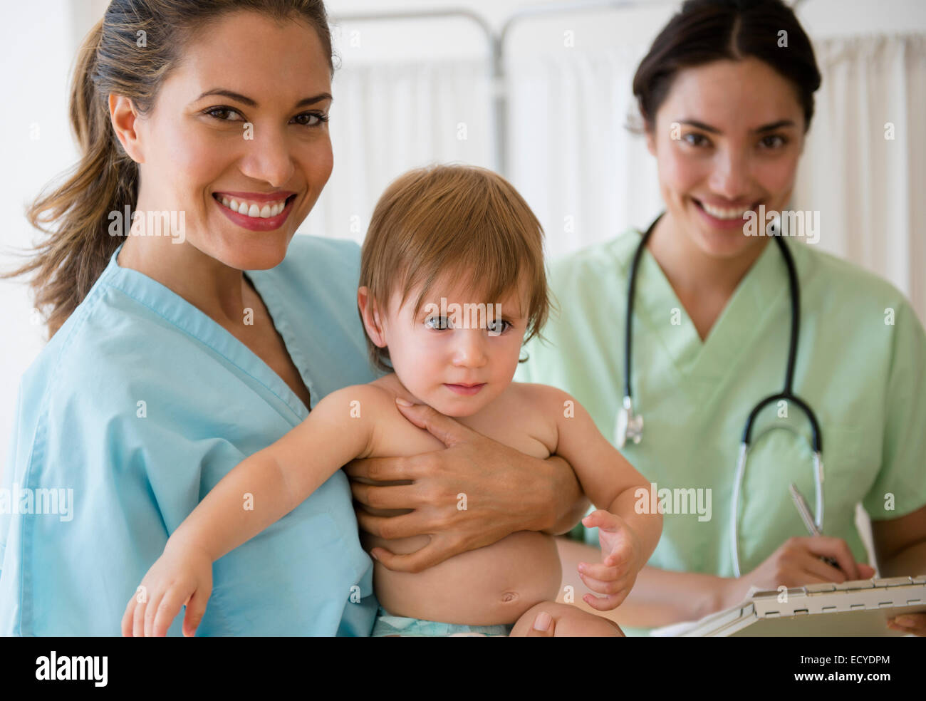 Medico pediatra e infermiere azienda bambina in ospedale Foto Stock