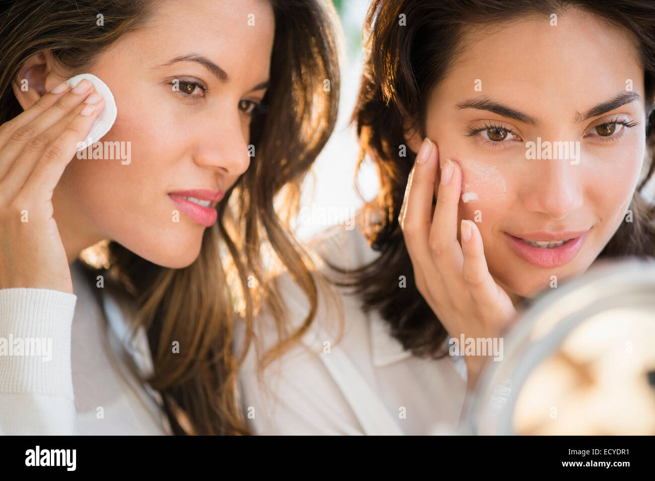 Donne ispaniche applicando specchio dello specchio Foto Stock