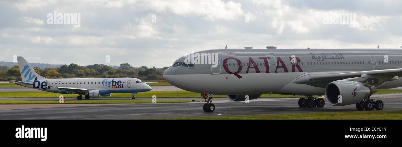 Il Qatar un velivolo con flybe aeromobile in background all'Aeroporto di Manchester Foto Stock