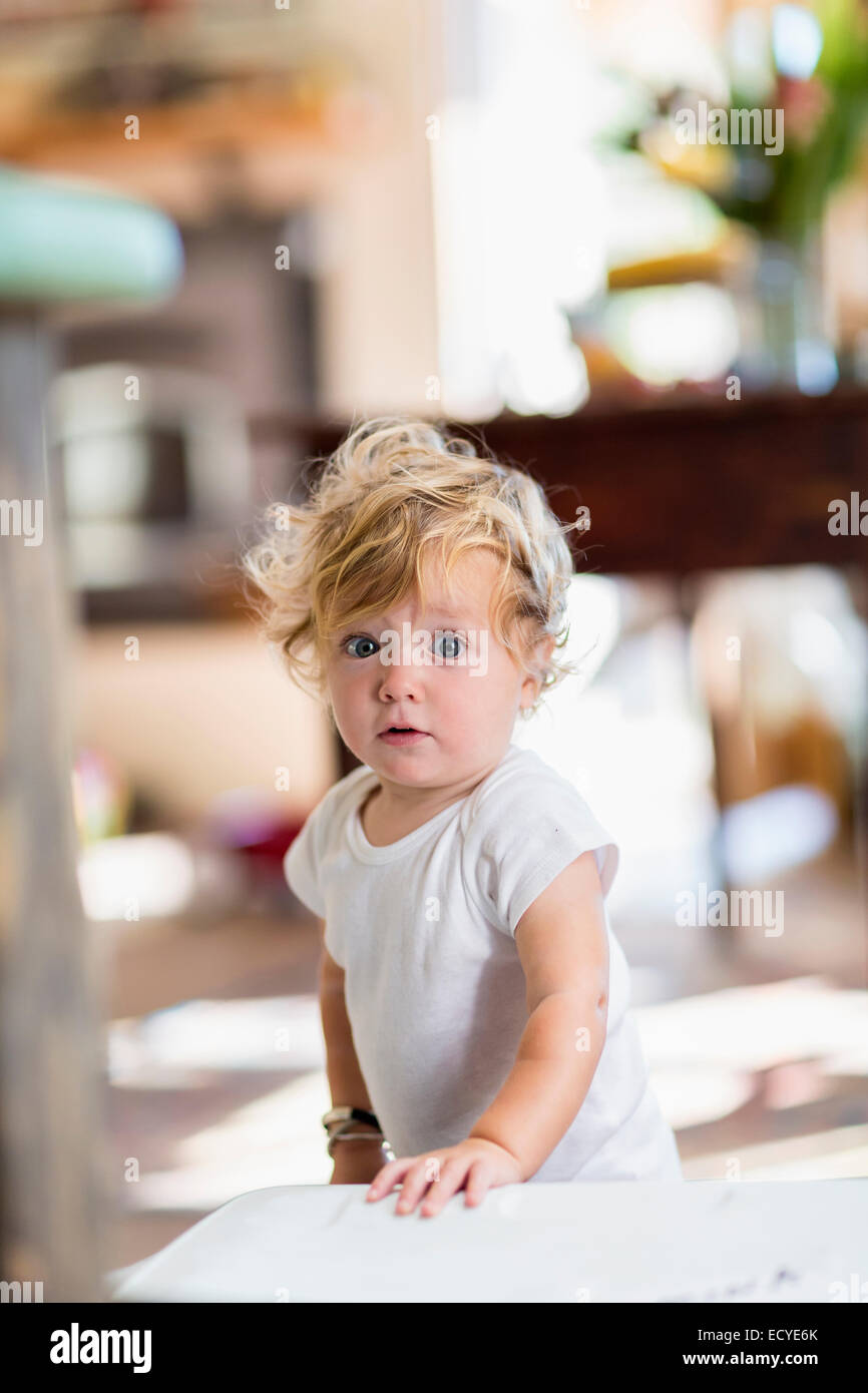 Sorpreso Caucasian baby boy in piedi in ambienti interni Foto Stock