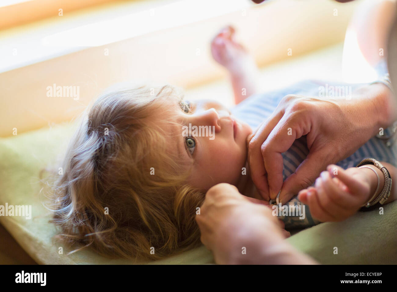 Madre medicazione baby boy sulla modifica tabella Foto Stock