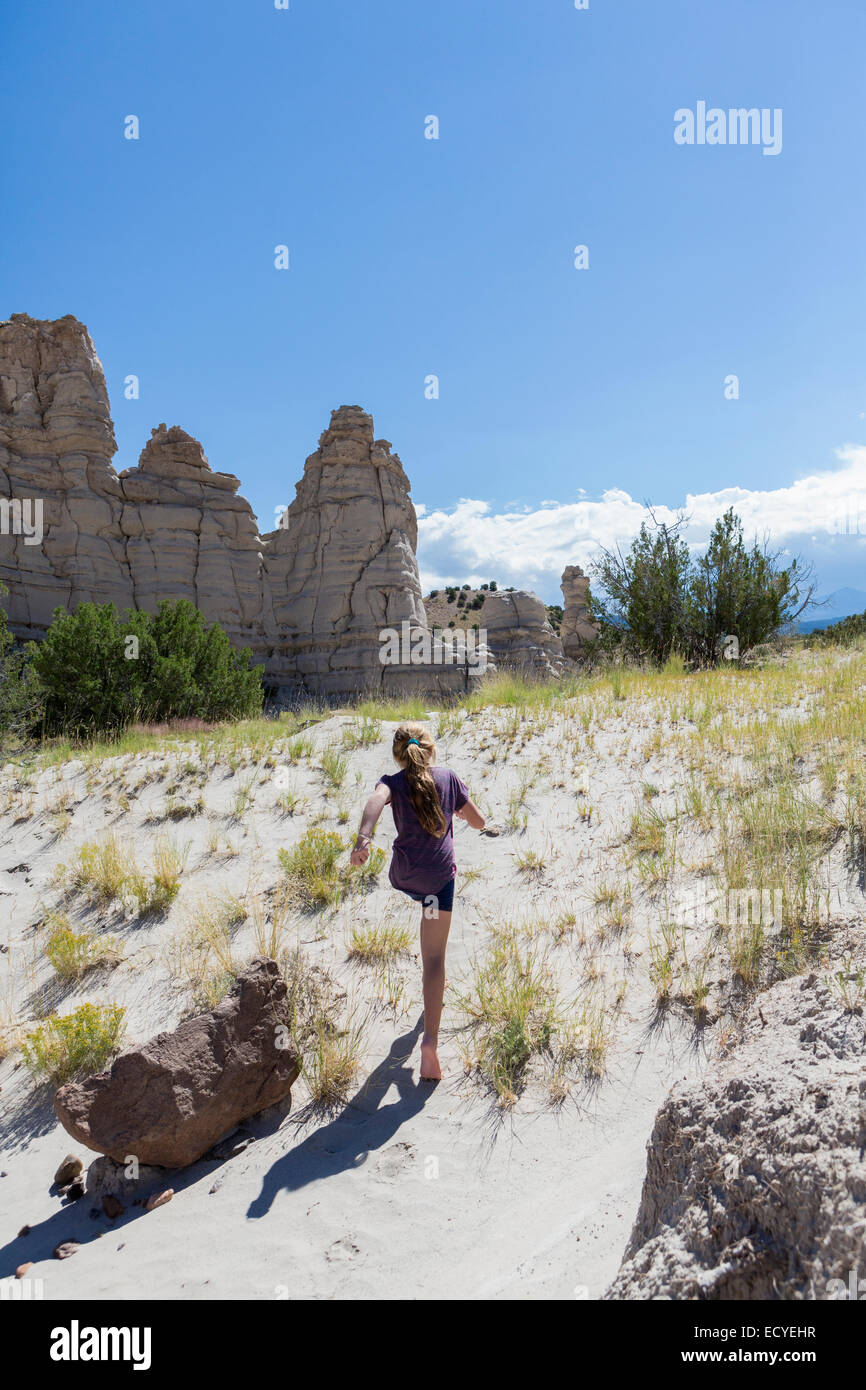 Ragazza caucasica esplorare formazioni rocciose, Abiquiu, Nuovo Messico, Stati Uniti Foto Stock