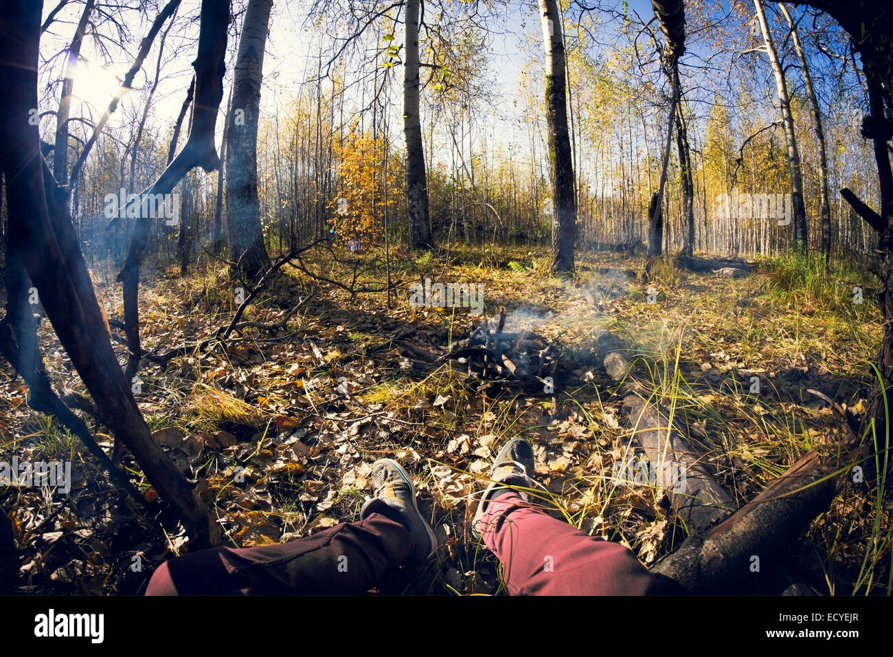 Lente fish-eye di gambe seduta dal fumo del fuoco Foto Stock