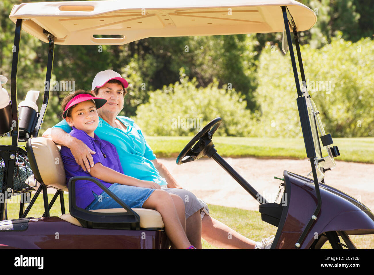 Nonna e nipote la guida carrello da golf sul corso Foto Stock