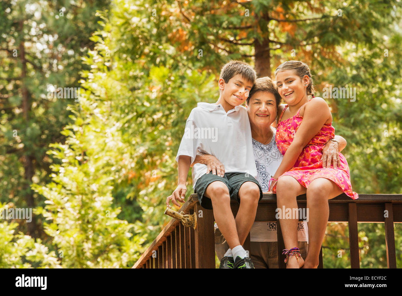 Nonna e nipoti sorridente sul parapetto Foto Stock