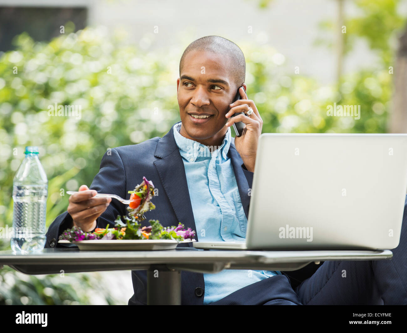 Imprenditore nero lavorando e mangiare il pranzo all'aperto Foto Stock