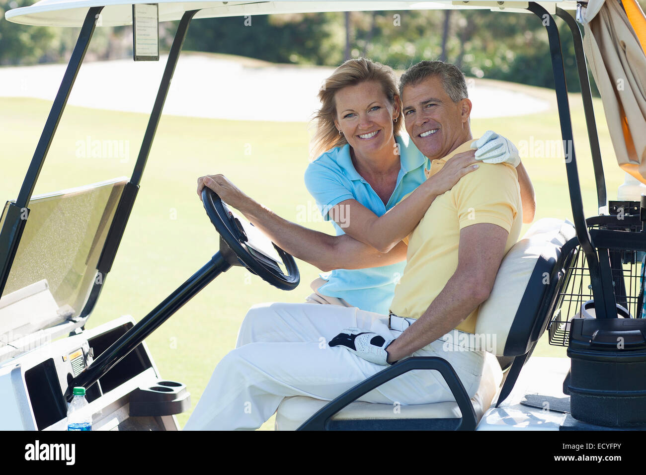 Coppia caucasica abbracciando in golf cart sul corso Foto Stock