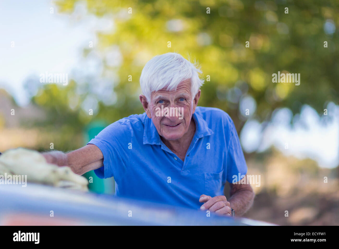Senior uomo caucasico il lavaggio auto all'aperto Foto Stock