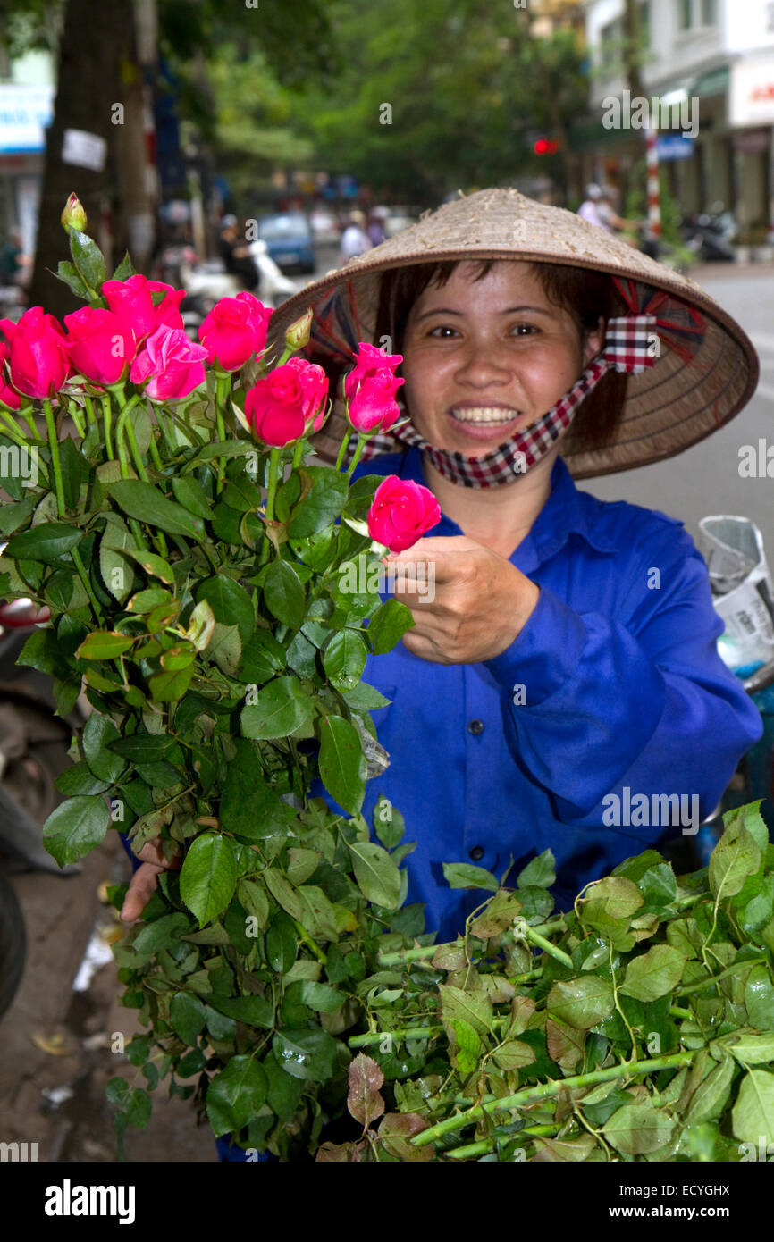 Vietnamese street venditore a vendere le rose in Hanoi, Vietnam. Foto Stock