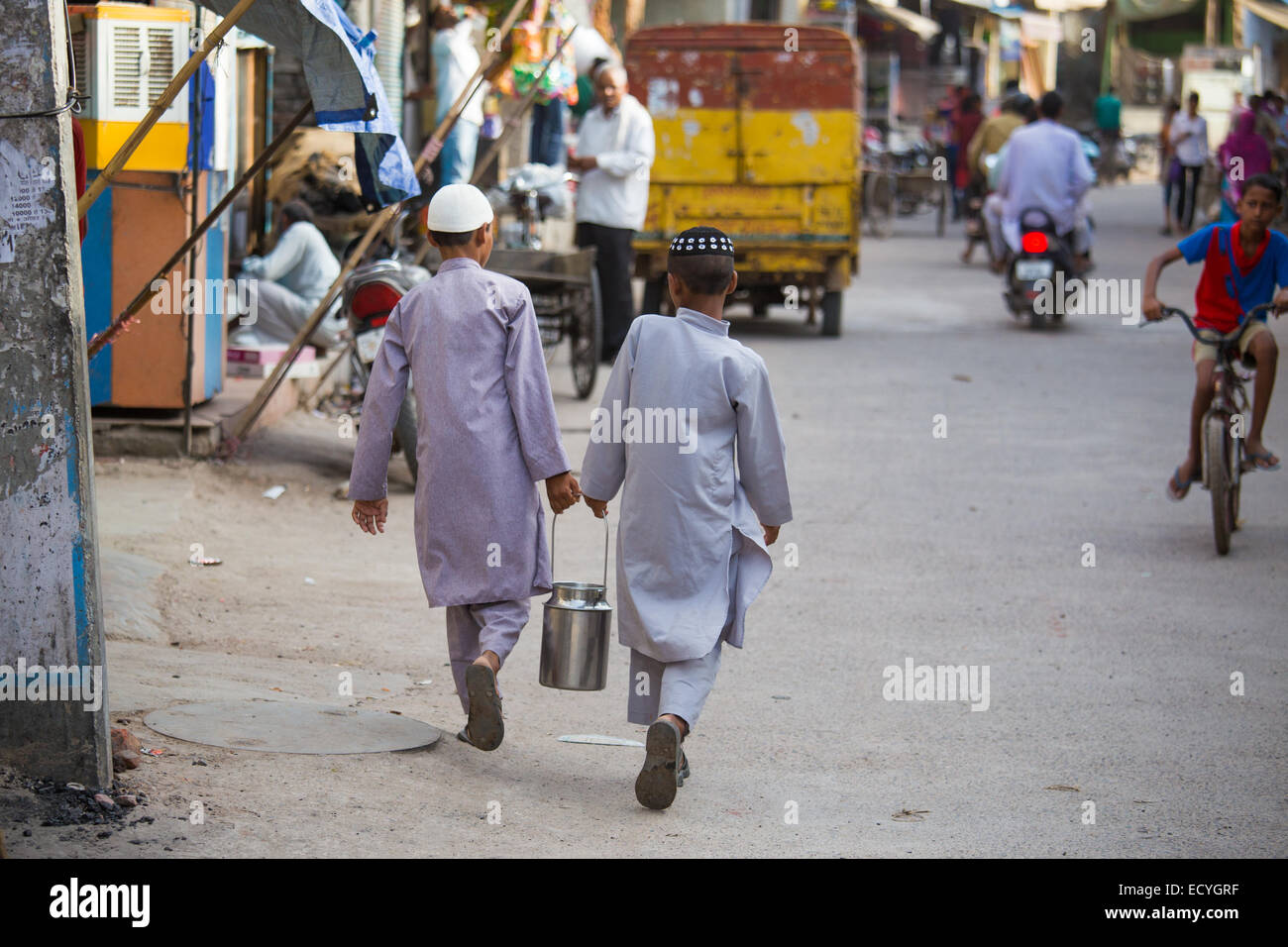 Ragazzi musulmani che trasportano il latte in Delhi, India Foto Stock