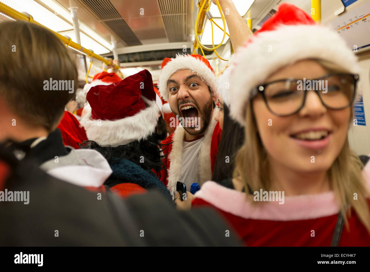 Persone vestite come Babbo Natale su un treno della metropolitana. Londra, Regno Unito. Foto Stock