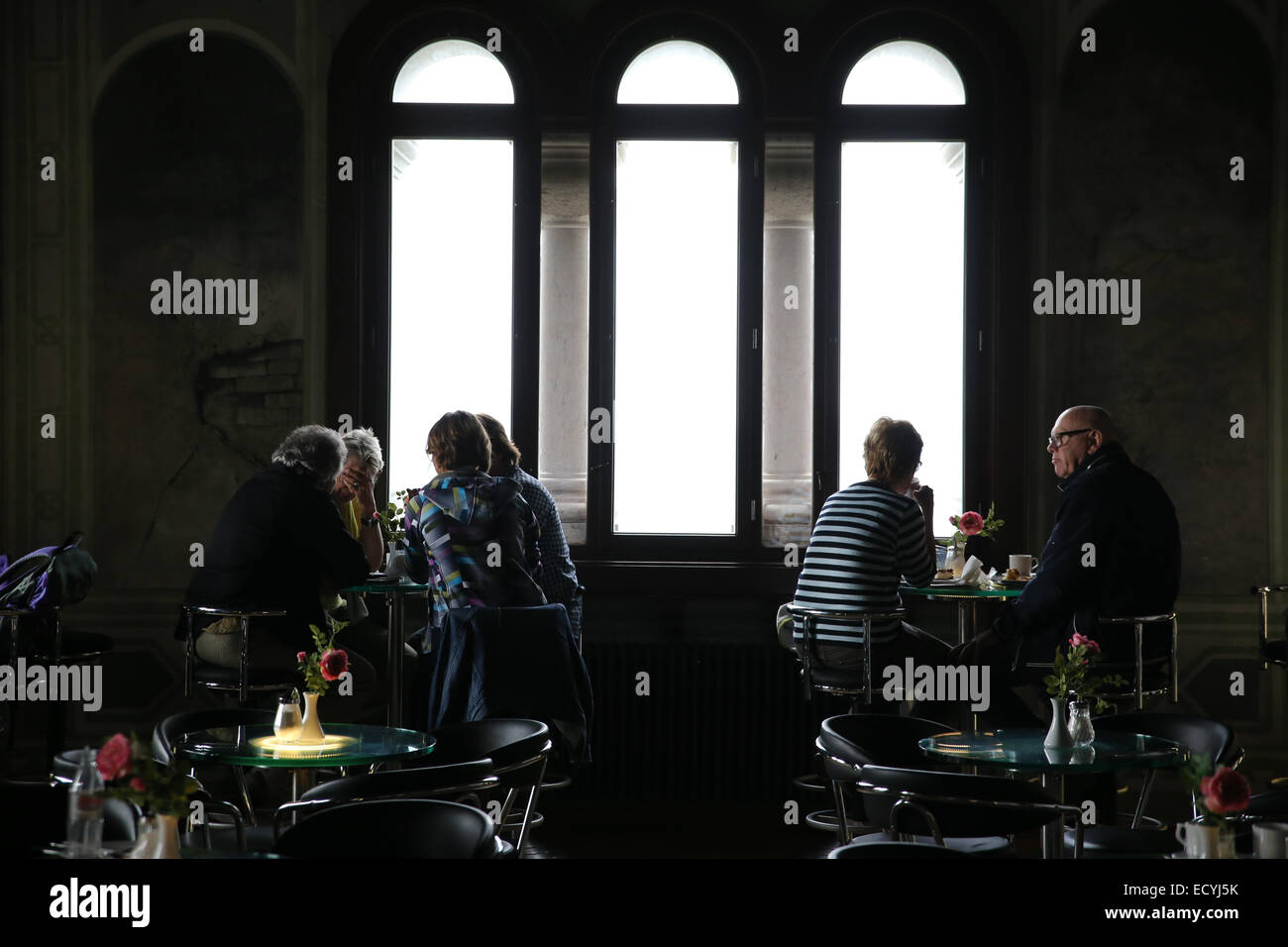 Le persone all'interno piccolo cafe grandi finestre Foto Stock
