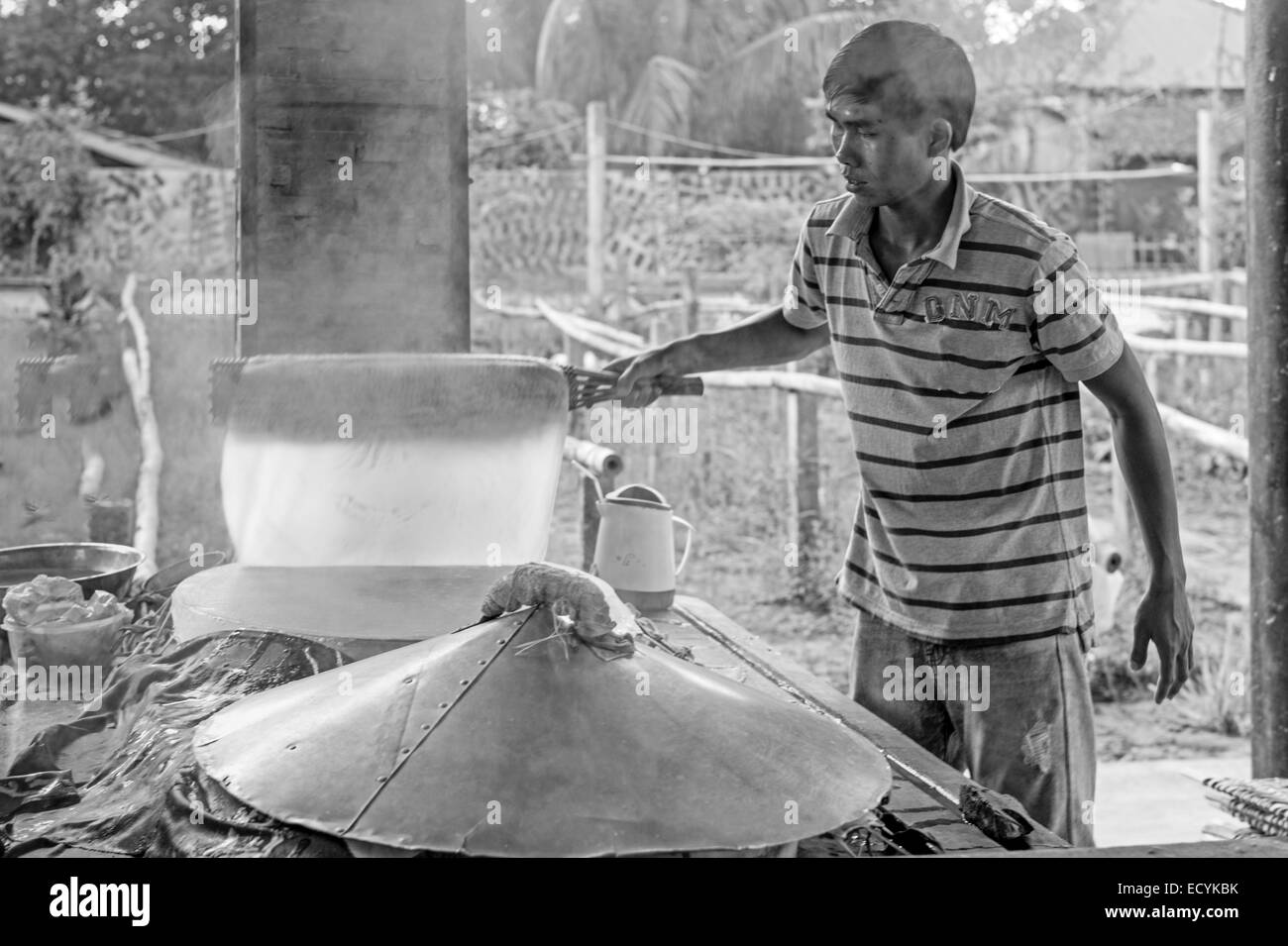 Famiglia vietnamita che lavorano nel loro piccolo home fabbrica di carta di riso e spaghetti di riso e la loro essiccazione su rack di bambù. Foto Stock