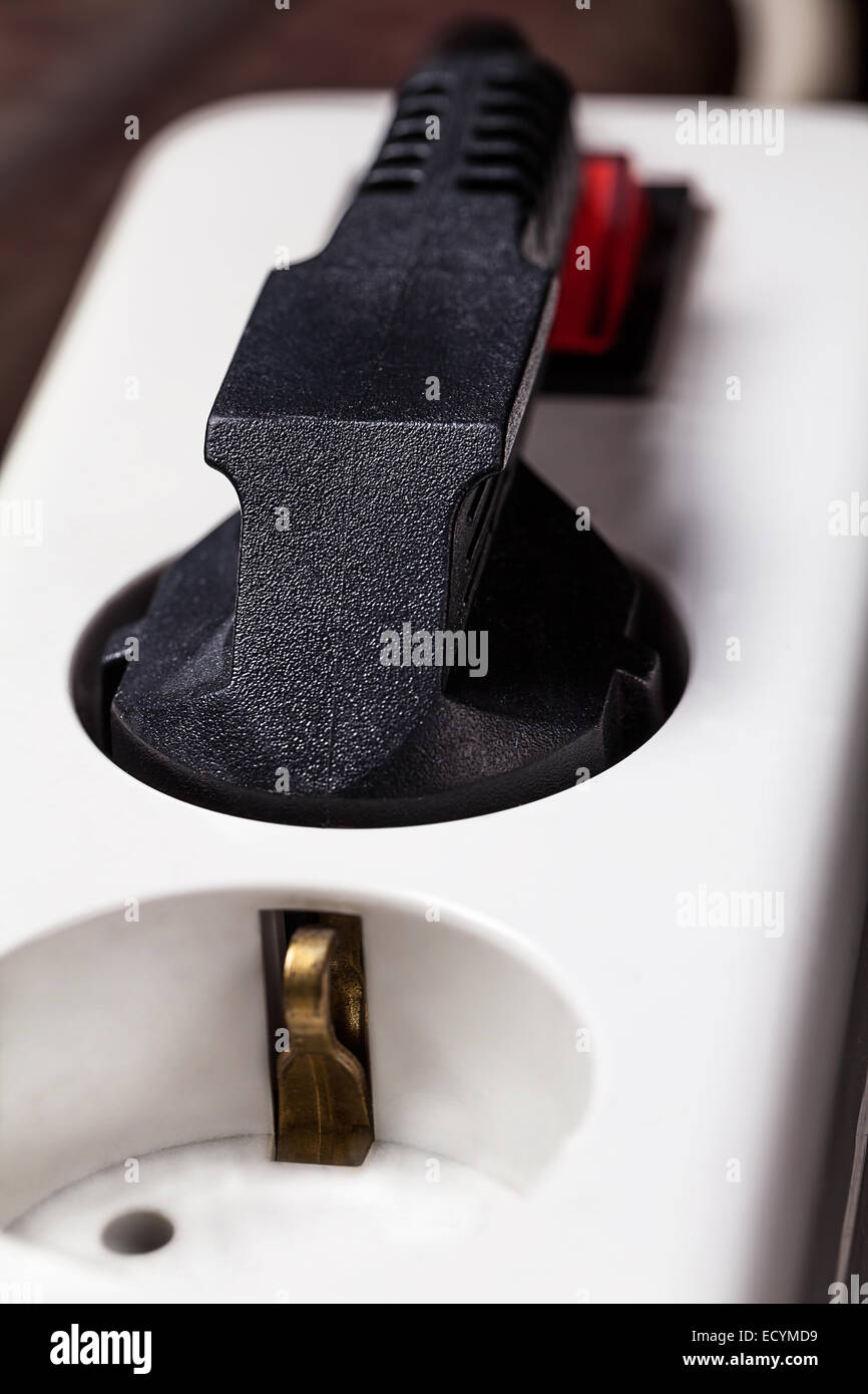 Il cavo elettrico collegato a una ciabatta multipresa bianca o blocco di estensione Foto Stock