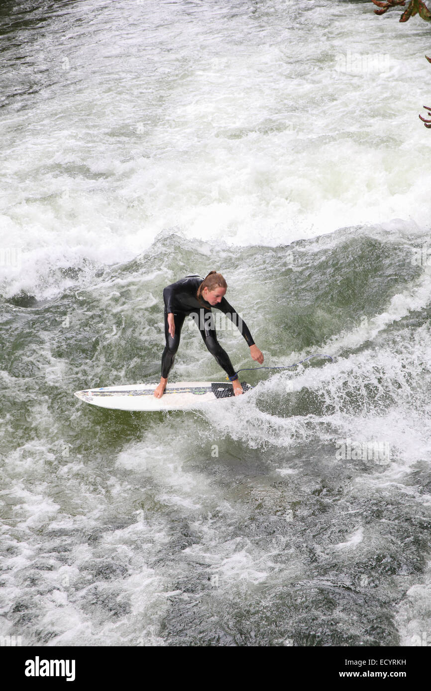 Ragazza bionda donna navigare in acqua di fiume wave Monaco di Baviera Foto Stock