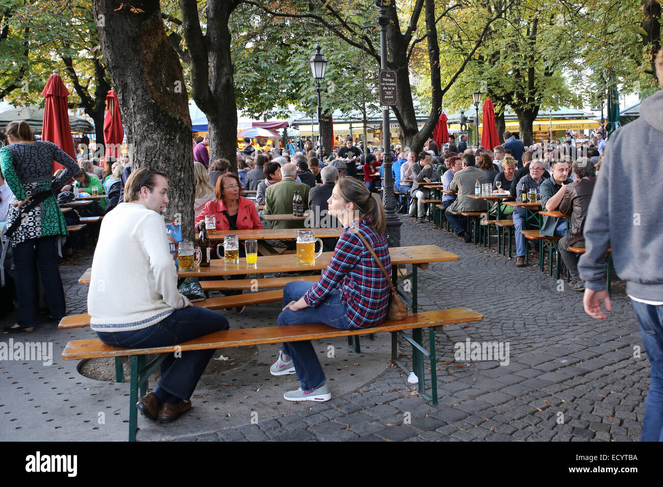Le persone godono di birra all'aperto Viktualienmarkt Monaco di Baviera Foto Stock
