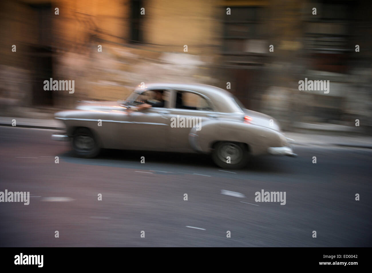 Scialbo marrone vintage americano auto taxi guida su Havana Cuba street passando in motion blur Foto Stock