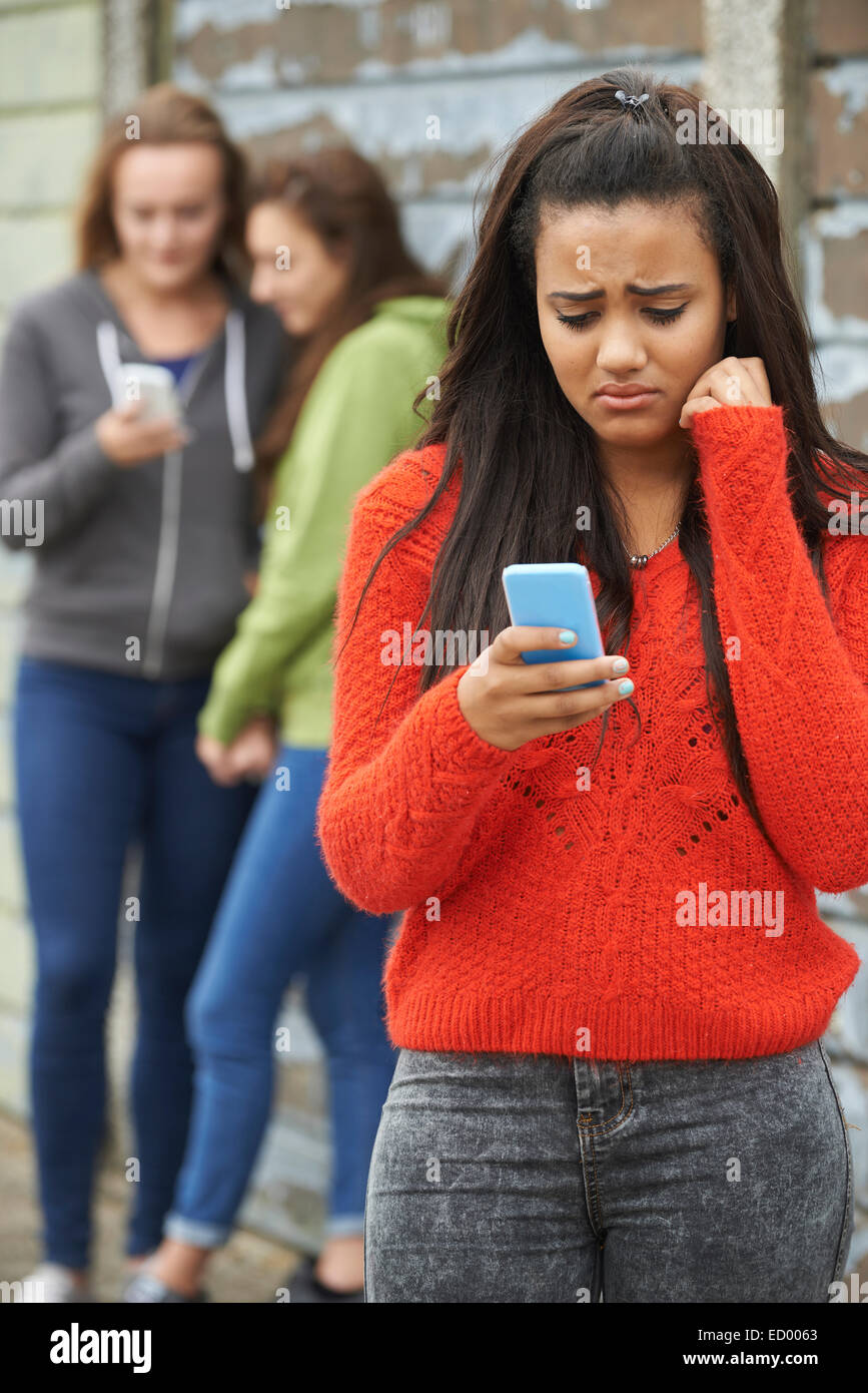 Ragazza adolescente di essere vittima di bullismo mediante messaggio di testo Foto Stock